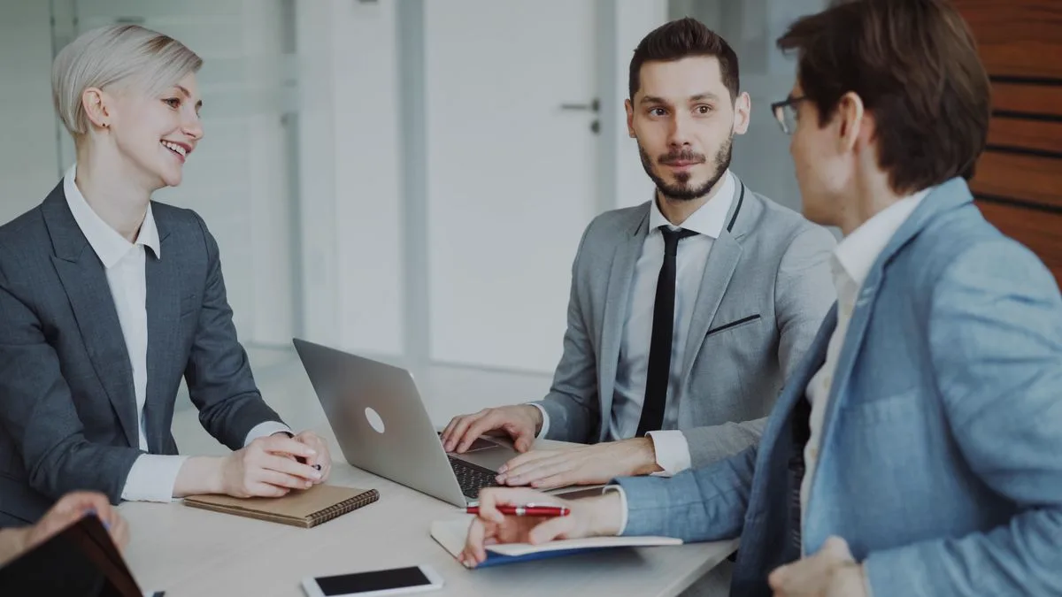 Consultants reviewing a client engagement on a laptop