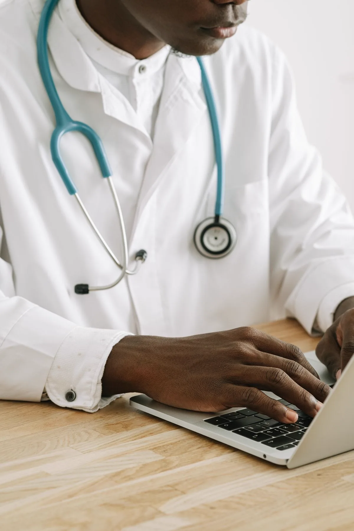 Physician updating a patient's clinical record on a laptop