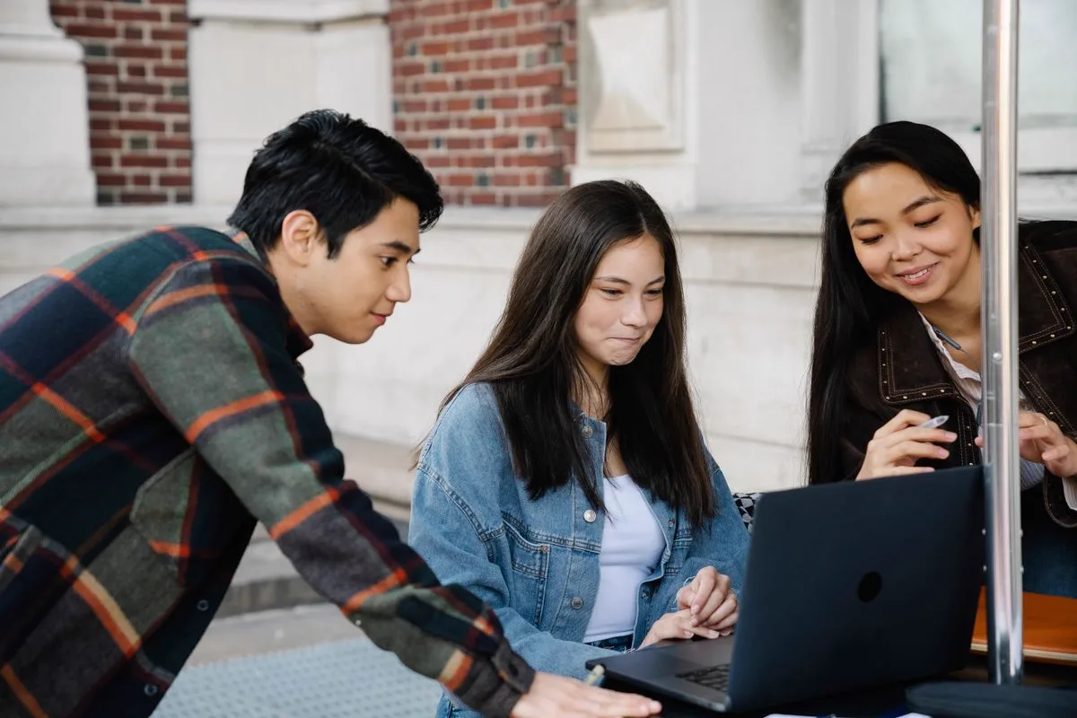 Students working together on a laptop-based learning exercise