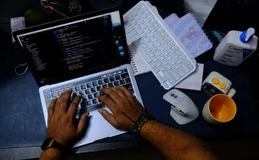 Hands typing on a laptop with logistics tracking software on screen