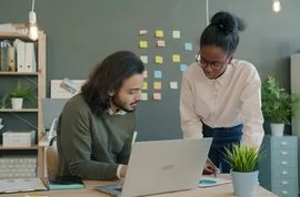 Consultants reviewing a client engagement on a laptop